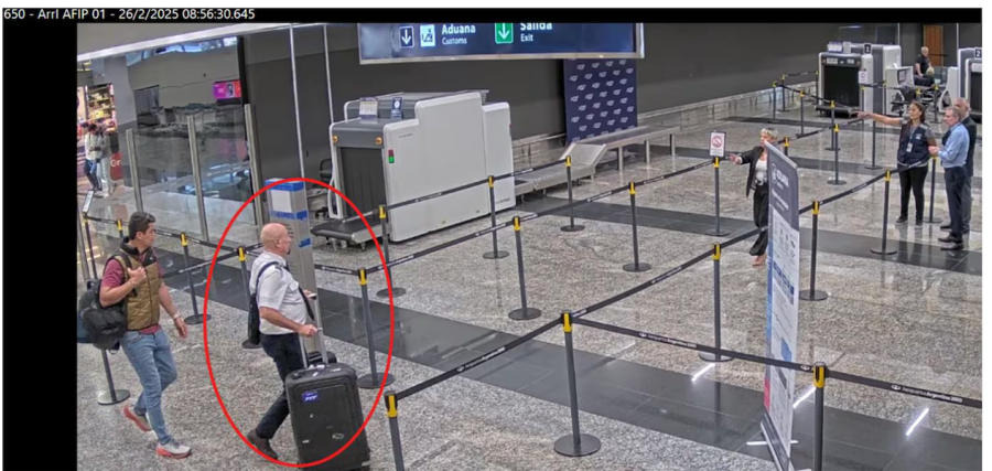 <b>Uno de los tripulantes del avión es dirigido por un agente aduanero para evitar el control de valijas. (Foto: TN).</b>